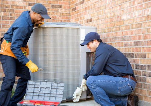 Multi-ethnic team of blue collar air conditioner repairmen at work.  They prepare to begin work by gathering appropriate tools from their tool box.